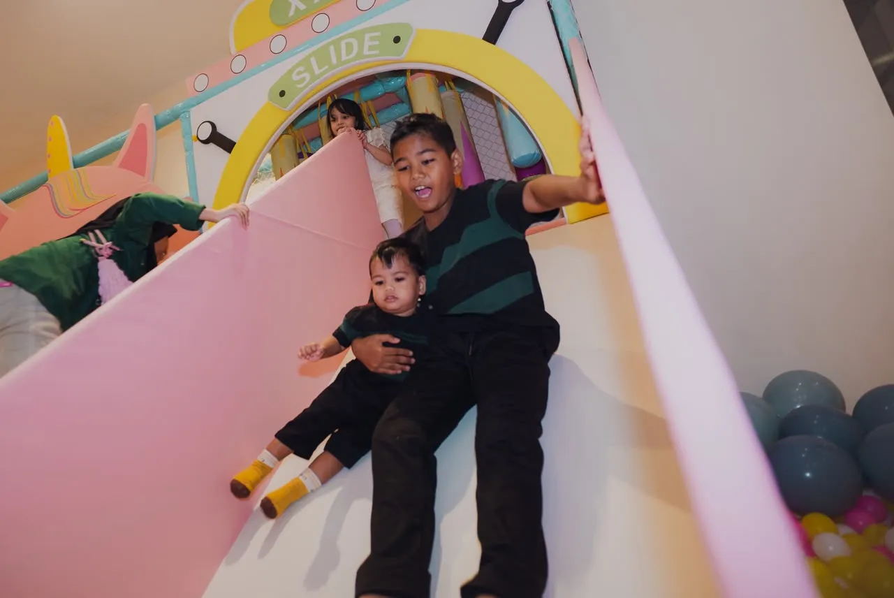 Children sliding down the pastel slide at Lulu